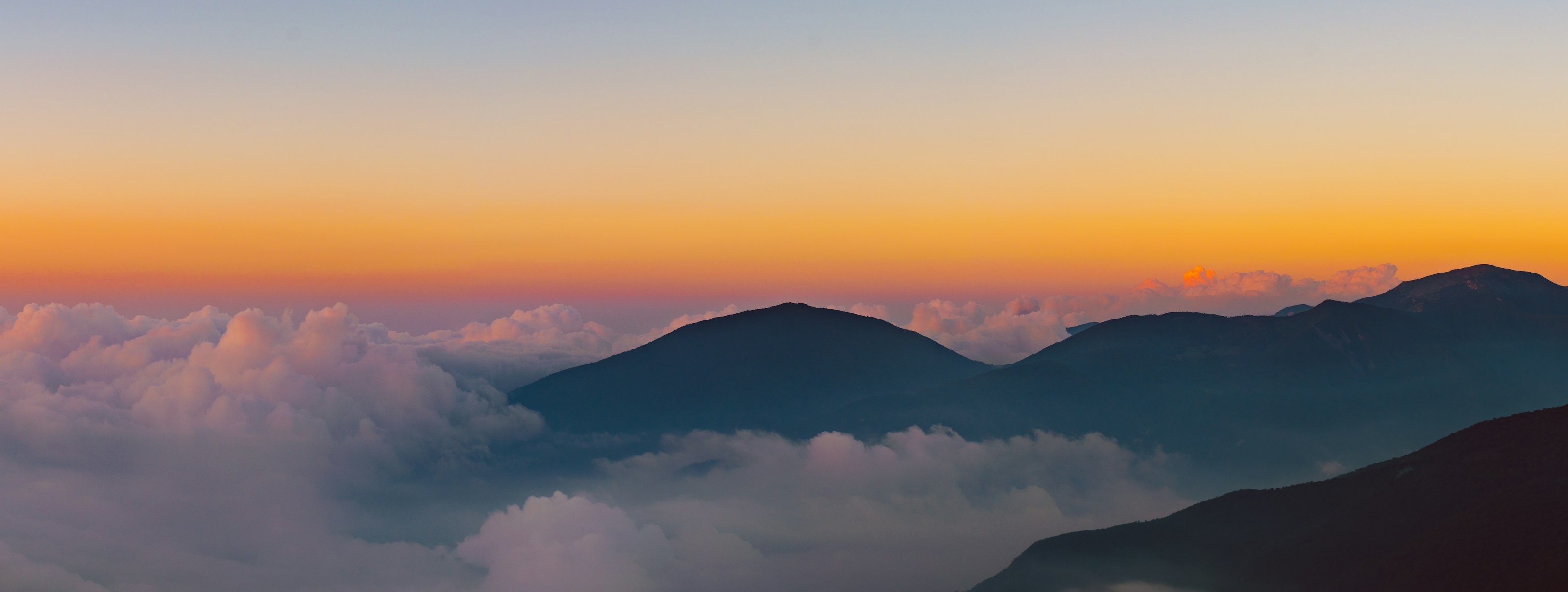 Chaîne de montagnes au coucher de soleil, dans la brume